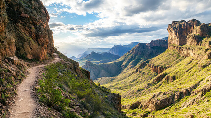 Obraz premium A panoramic view of a rugged hiking trail winding up a steep mountain pass.