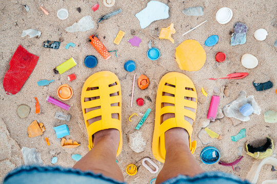 Colorful Sandals on a Beach Littered With Plastic Waste