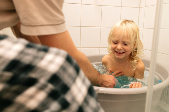 Father and daughter having fun during bath time