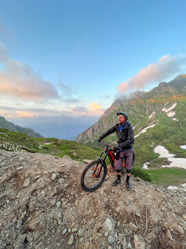 Mountain biker at sunset on rocky viewpoint
