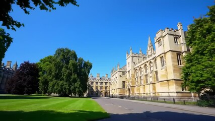 Historic university building with green lawns and trees under a clear blue sky
