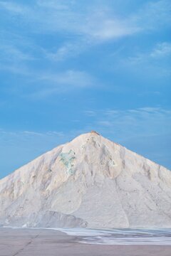 Tall salt mound against bright sky
