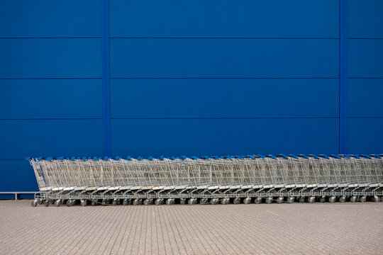 Row of Shopping Carts Against Blue Wall