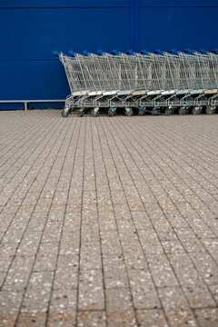 Row of Shopping Carts Against Blue Wall