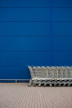 Row of Shopping Carts Against Blue Wall