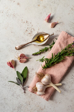 Food still life featuring garlic, herbs and oil