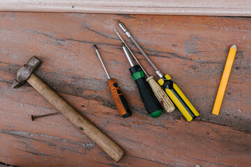 Tools arranged on wooden surface for repair tasks