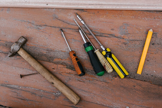 Tools arranged on wooden surface for repair tasks