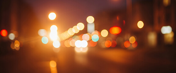 Blurred city street at night illuminated by vibrant lights, with vehicles in motion creating dynamic streaks and a lively, energetic urban atmosphere.