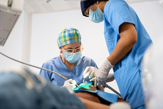 Dentists performing dental implant surgery on patient