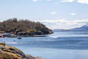 Scenic Lofoten fjords, snowy mountains, green fields and coastal landscapes in spring. Stunning spring views of Lofoten Islands, Norway – snowy mountains, sparkling fjords, green fields.