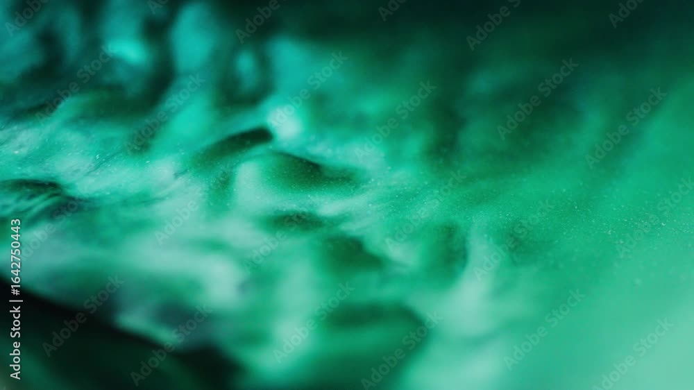 Poster macro shot of green ink with blue reflections and glitter particles, creating abstract flowing shape