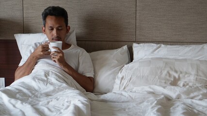 a man drinking in a bed