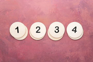 Wooden round discs numbered 1 2 3 4 in a row on red background