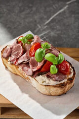 Roast beef bruschetta with tomatoes, moody lighting, overhead composition, artisan bread