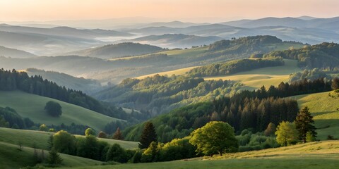Mountain landscape with snow-capped peaks, green valleys, and clouds against a bright summer sky
