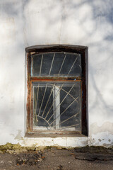 Old arched window with rusty metal bars