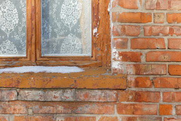Vintage wooden window with lace curtain in brick wall