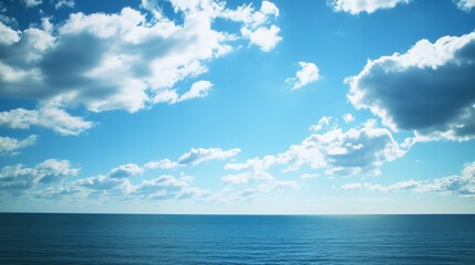 Obraz premium Azure sky meets tranquil sea. Fluffy clouds drift across a brilliant blue sky, meeting a calm, deep blue ocean