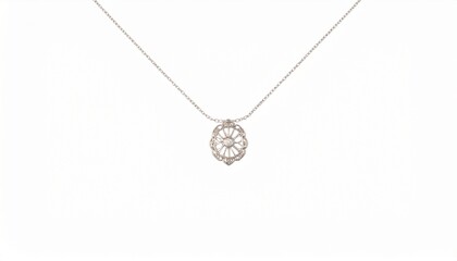 Fototapeta premium Elegant necklace featuring a thin chain and a symmetrical, intricately designed metal pendant—possibly silver or white gold—attached via a small loop, showcasing refined craftsmanship and delicate sty