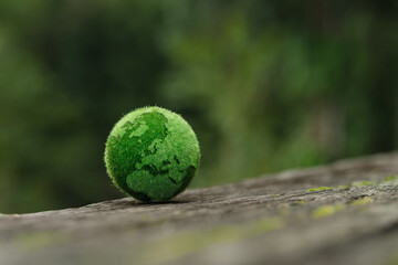 Green globe with continents made of grass texture, symbolizing environmental sustainability and...