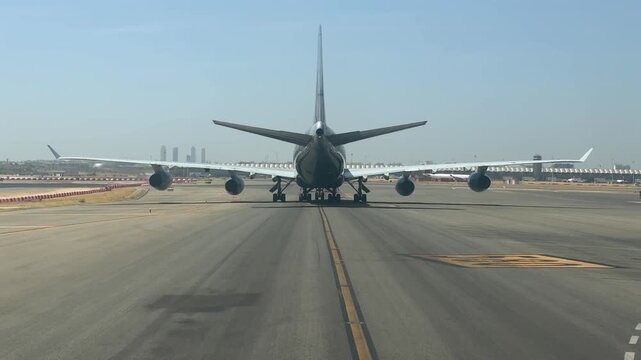 An immersive pilot&rsquo;s view from cockpit, taxiing behind a massive 4-engine jet in Madrid airport, in a scorching and hazy summer afternon.