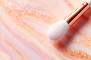 Closeup of slanted makeup brush on neutral textured backdrop