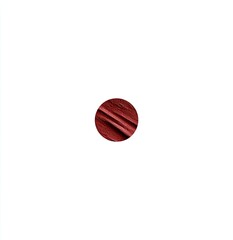 Close-up of a small, round swatch of a deep reddish-brown lipstick