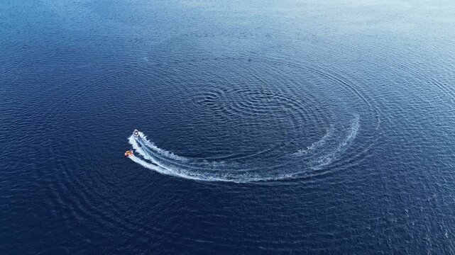 Motorboat making circles on a deep blue water surface Drone stady shoot. Boat leaving the frame. Croatia
