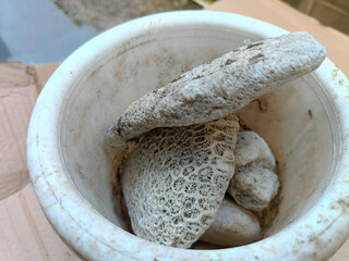 White beach stones like sea coral reefs in a white pot.