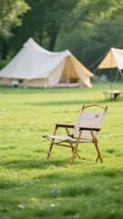An outdoor camping scene with a folding chair placed on the grass and several white tents in the background, creating a relaxed and cozy natural leisure atmosphere.