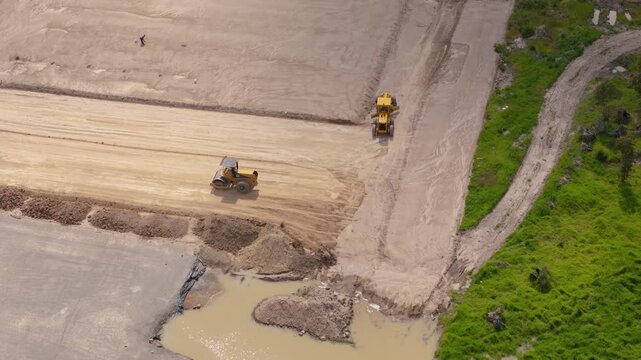 Heavy machinery road roller flattening soil at construction site