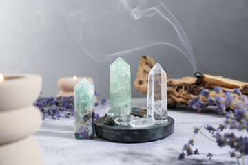 Aura. Different crystals, lavender, burning candles and Palo Santo stick on white textured table