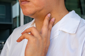 Sore throat, tonsillitis, and bronchial inflammation in a patient clutching their neck against a...
