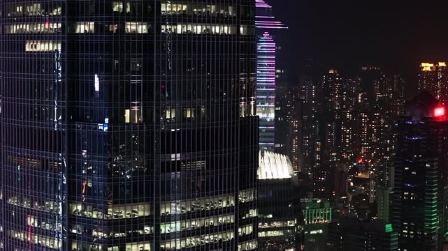Cityscape Featuring Glowing Skyscrapers Rising Against Dark Evening Sky, Showcasing Modern Architectural Design And Urban Development Of Bustling Financial Metropolis. Financial District in Hong Kong