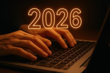 Hands typing on a laptop with the year 2026 glowing in neon orange above