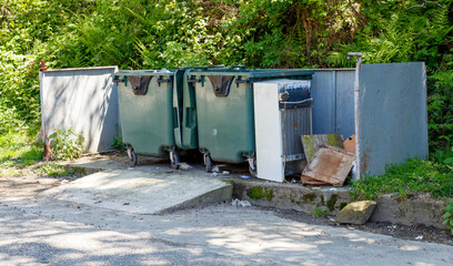 A trash can is next to a dumpster
