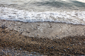 A rocky beach with a large wave crashing onto the shore