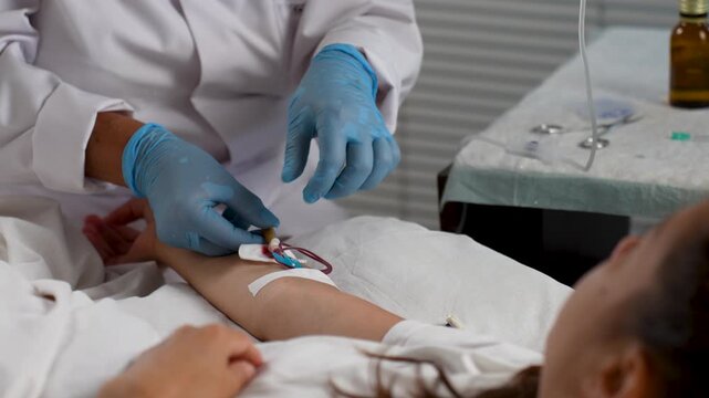 Nurse inserting intravenous catheter into patient&rsquo;s arm