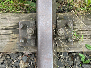 Old overgrown railway tracks. Unused railway in need of repair, historical rails and sleepers