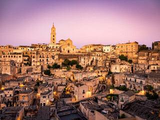 Fototapeta premium Sunset in the beautiful Sassi of Matera, with stone houses and streets, covered in warm golden light 