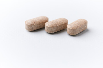 Lion&rsquo;s mane mushrooms tablets that have beneficial effects on the body, especially the brain, heart, and intestines. Bright paper background. Soft focus. Close up. Copy space.	