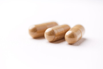 Lion’s mane mushrooms tablets that have beneficial effects on the body, especially the brain, heart, and intestines. Bright paper background. Soft focus. Close up. Copy space.	