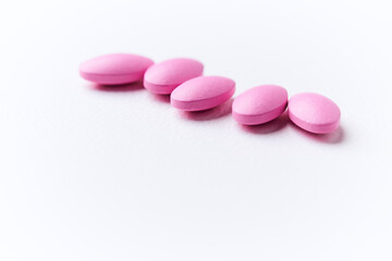 Multivitamin tablets on bright paper background. Close up. Copy space	
