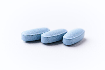 Multivitamin tablets on bright paper background. Close up. Copy space	