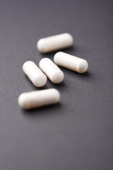 HMB capsules on dark background. Soft focus. Close up. Copy space.	