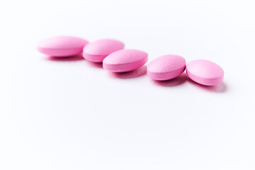 Multivitamin tablets on bright paper background. Close up. Copy space	