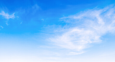 the sky is clear blue with fluffy white clouds, the sky is very bright, and the sun shines.