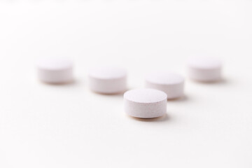 Creatine tablets on paper background. Soft focus. Close up. Copy space	