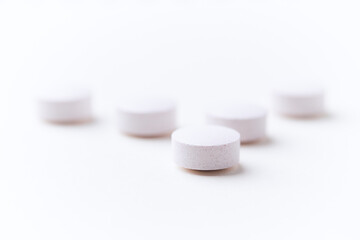 Creatine tablets on paper background. Soft focus. Close up. Copy space	